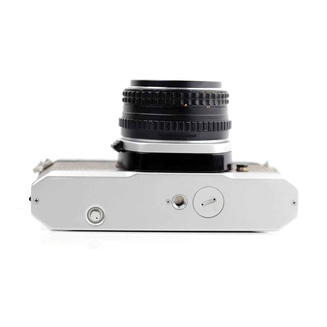 Bottom plate of Pentax K1000 SE film camera showing Taiwan lens mount and battery cover at ClubCamera.com