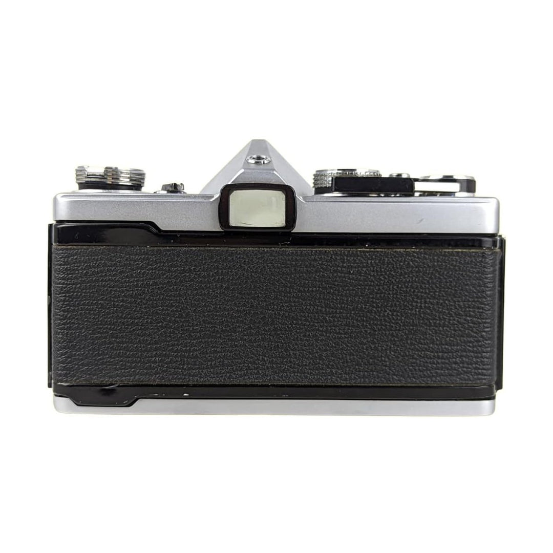 Olympus OM-1 silver film camera rear view with textured leatherette grip and manual controls at ClubCamera.com