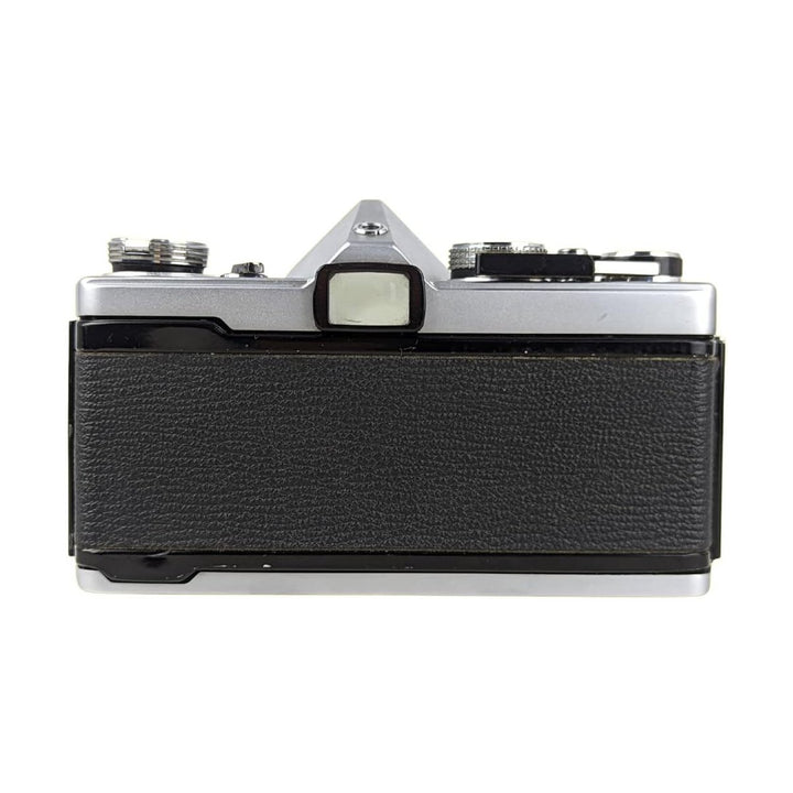 Olympus OM-1 silver film camera rear view with textured leatherette grip and manual controls at ClubCamera.com