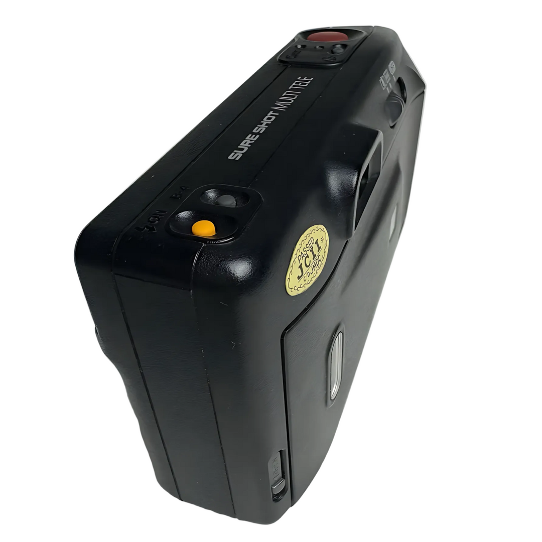 Side profile of black Canon Sure Shot Multi Tele highlighting textured grip and yellow compliance sticker by ClubCamera.com