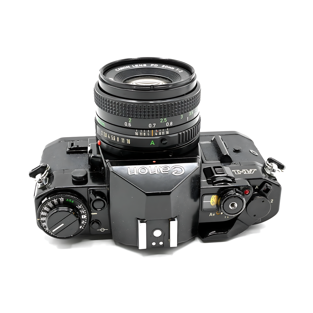 Top-down view of black Canon A-1 with FD 40mm lens displaying ASA shutter speed dials at ClubCamera.com