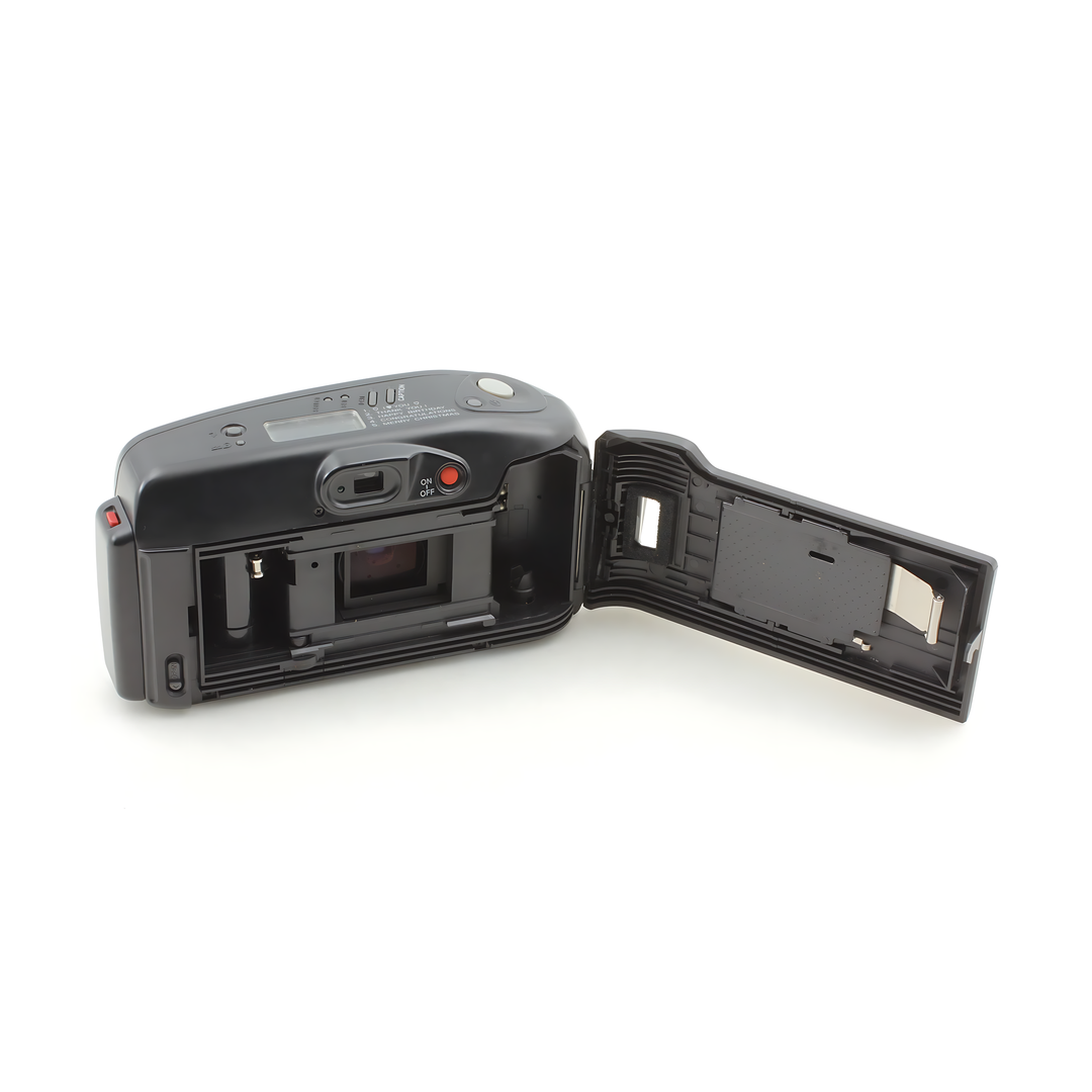 Open film door of black Canon Autoboy Panorama 35mm camera revealing internal spool holder and mirror assembly at ClubCamera.com