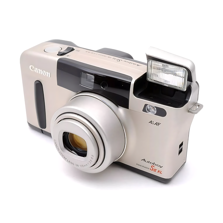 Beige Canon Autoboy Panorama S II XL with raised pop-up flash and engraved zoom lens barrel visible at ClubCamera.com
