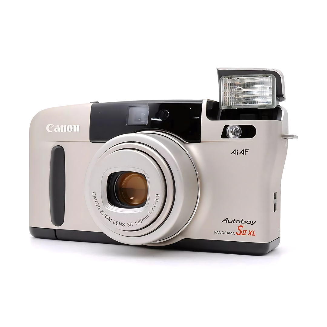Side-angle of silver Canon Autoboy S II XL panoramic camera with extended pop-up flash and amber-tinted glass lens element from ClubCamera.com