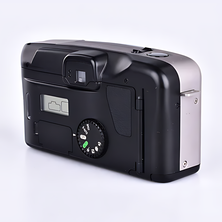 Rear view of black Canon Prima Super 135 showing optical viewfinder, shutter button, and circular mode dial with white icons from ClubCamera.com