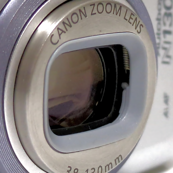 Macro detail of Canon Sure Shot 130uII lens aperture ring showing 38-130mm focal length specs at ClubCamera.com