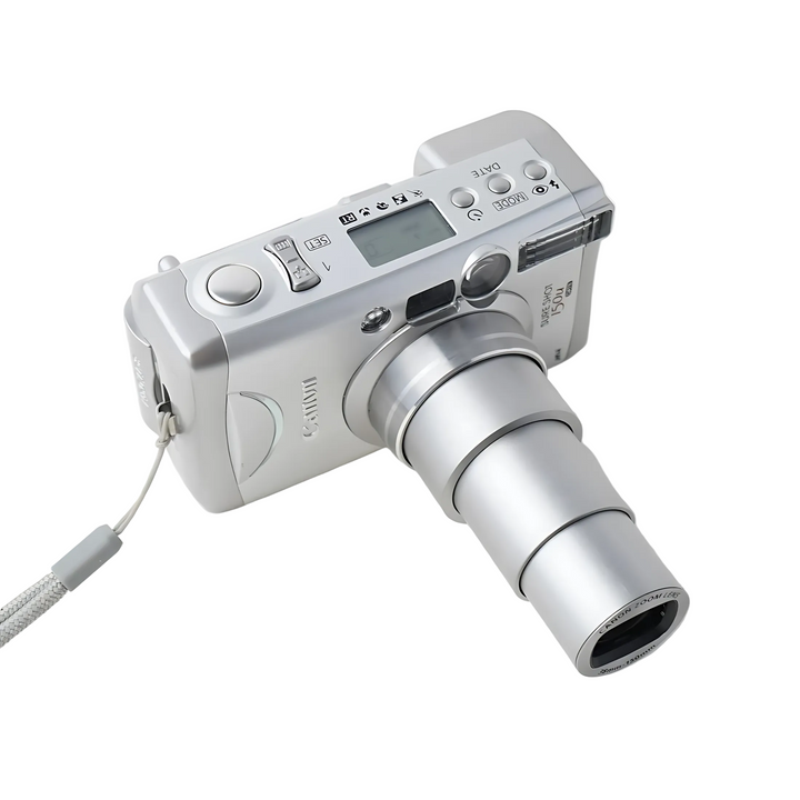 High angle diagonal view of silver Canon Sure Shot 150u with fully extended zoom lens reflecting studio light at ClubCamera.com
