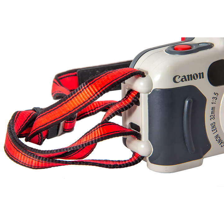 Red and black woven strap attached to Canon Sure Shot A-1 camera side eyelet for adventure use