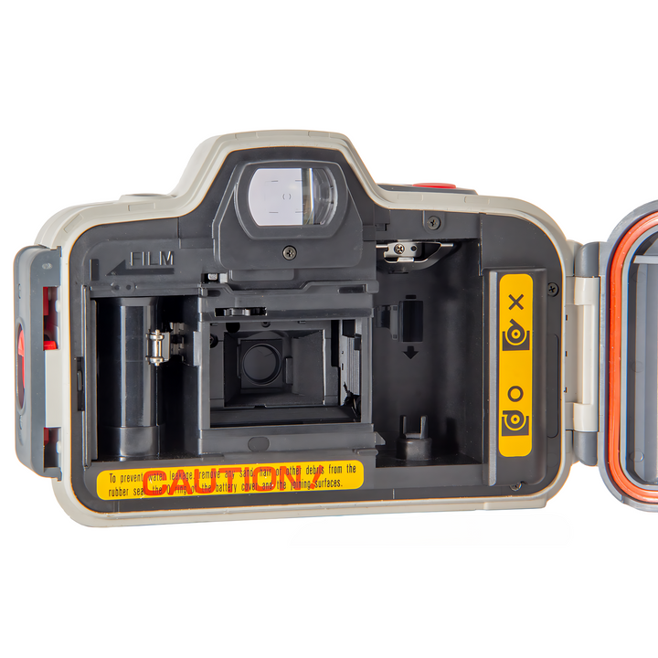 Canon Sure Shot WP-1 film chamber interior showing black spool holders and yellow water leakage warning label from ClubCamera.com