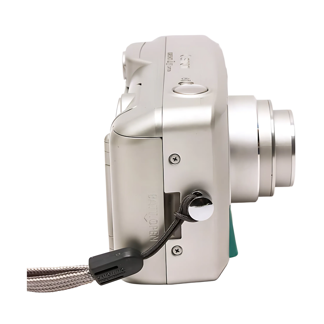 Left profile of silver Canon Sure Shot Z155 with gray braided wrist strap attached