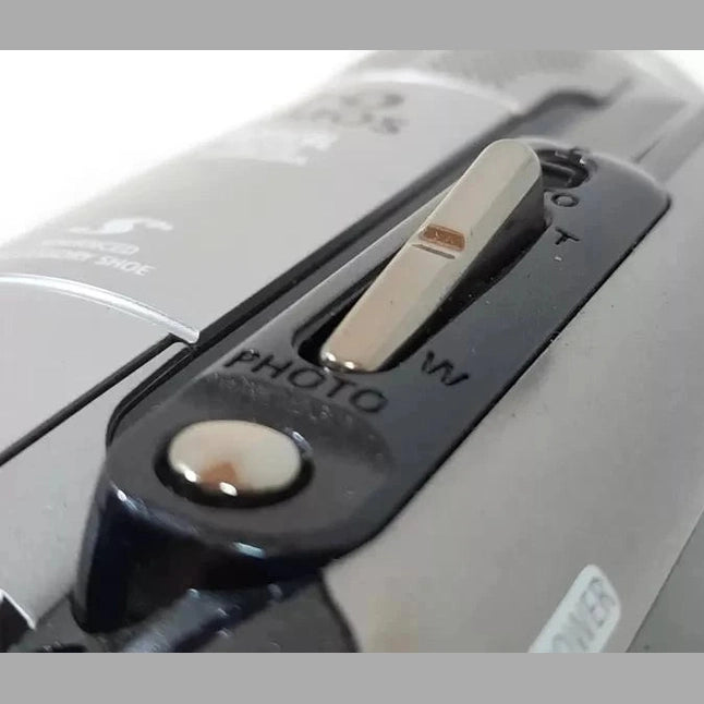 Close-up of silver mode switch on black Canon VIXIA HG10 showing PHOTO M and T settings at ClubCamera.com