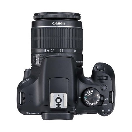 Top-down shot of black Canon EOS 1300D mode dial, shutter button, and flash housing with EF-S 18-55mm lens at ClubCamera.com