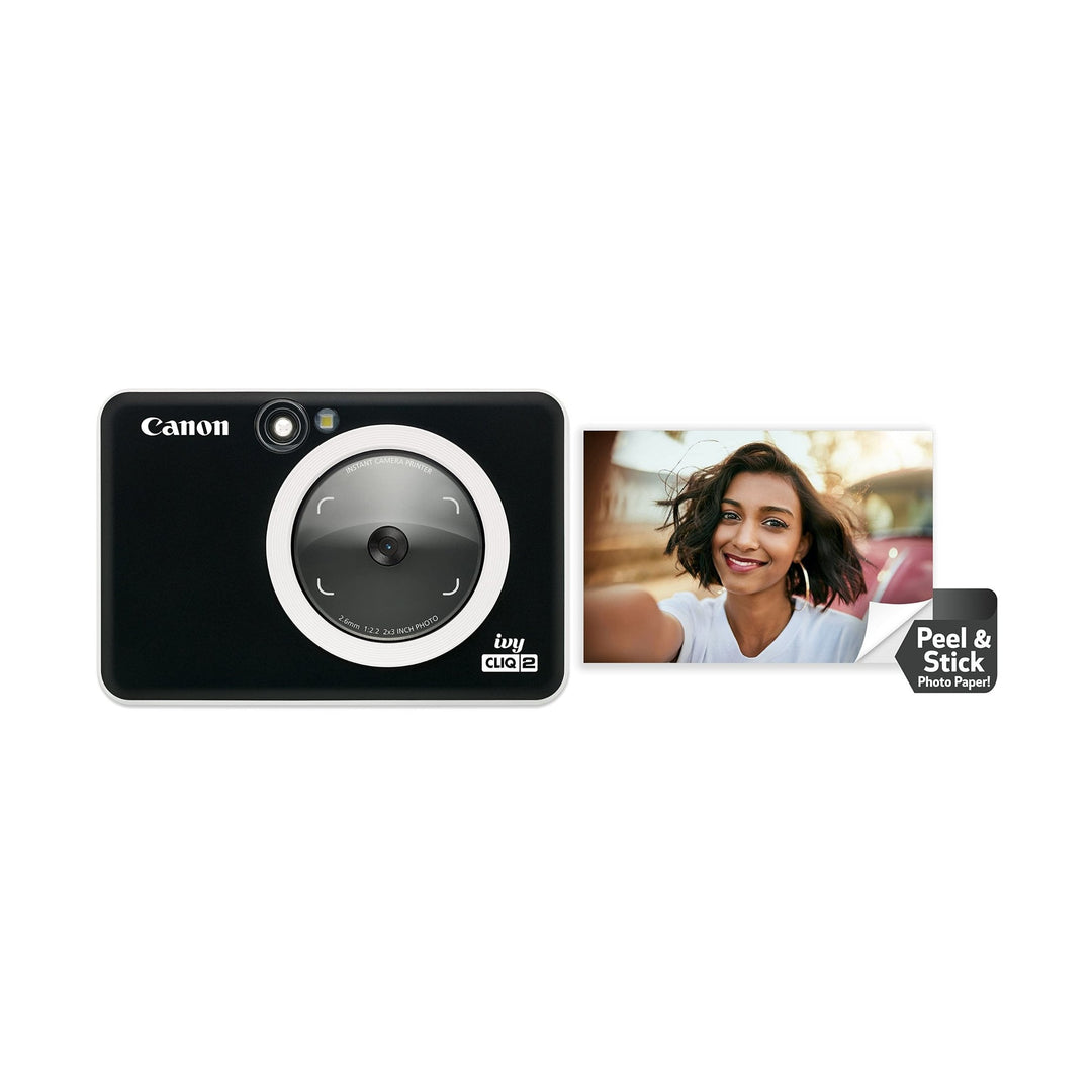 Canon Ivy Cliq2 Black Matte instant camera with textured finish and ring light next to red car peel-and-stick photo at ClubCamera.com
