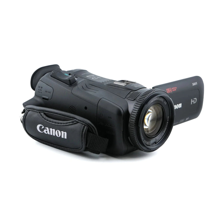 Canon XA11 digital video camcorder front angle showing 20x optical zoom lens and detachable leather grip from ClubCamera.com