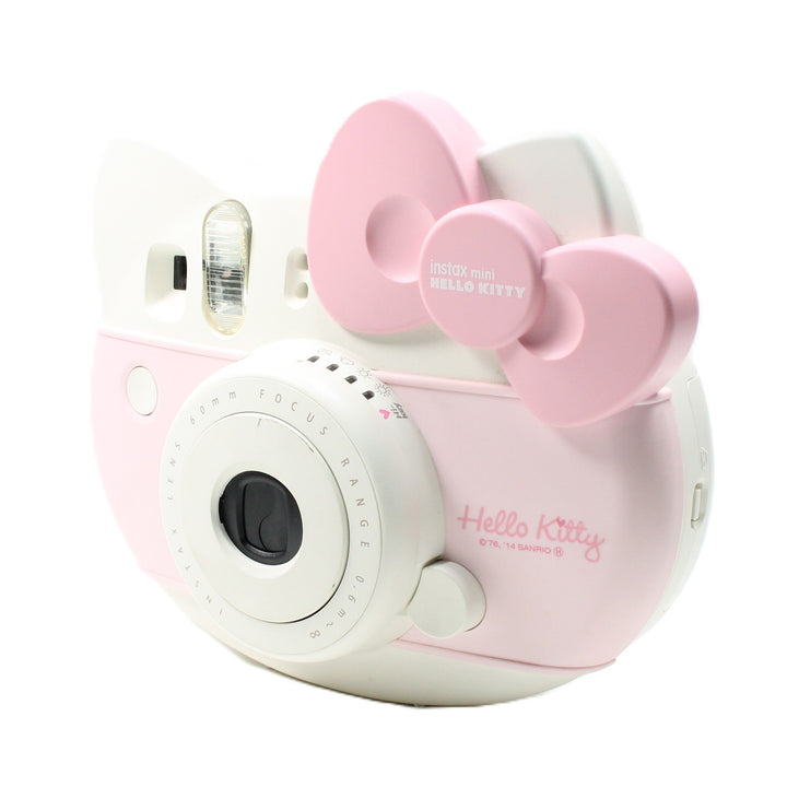 Three-quarter view of compact Fujifilm Instax mini HELLO KITTY camera showing rounded pink and white design at ClubCamera.com