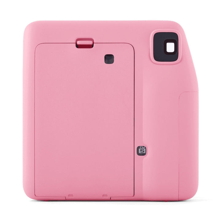 Back view of pink INSTAX Mini SE camera featuring film eject slot, battery door with red tab, and Selfie mode sticker by ClubCamera.com
