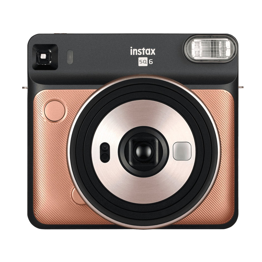 ClubCamera.com Fujifilm INSTAX Square SQ6 Blush Gold flat lay showing square lens assembly, diagonal grain texture, and black rose-gold contrast