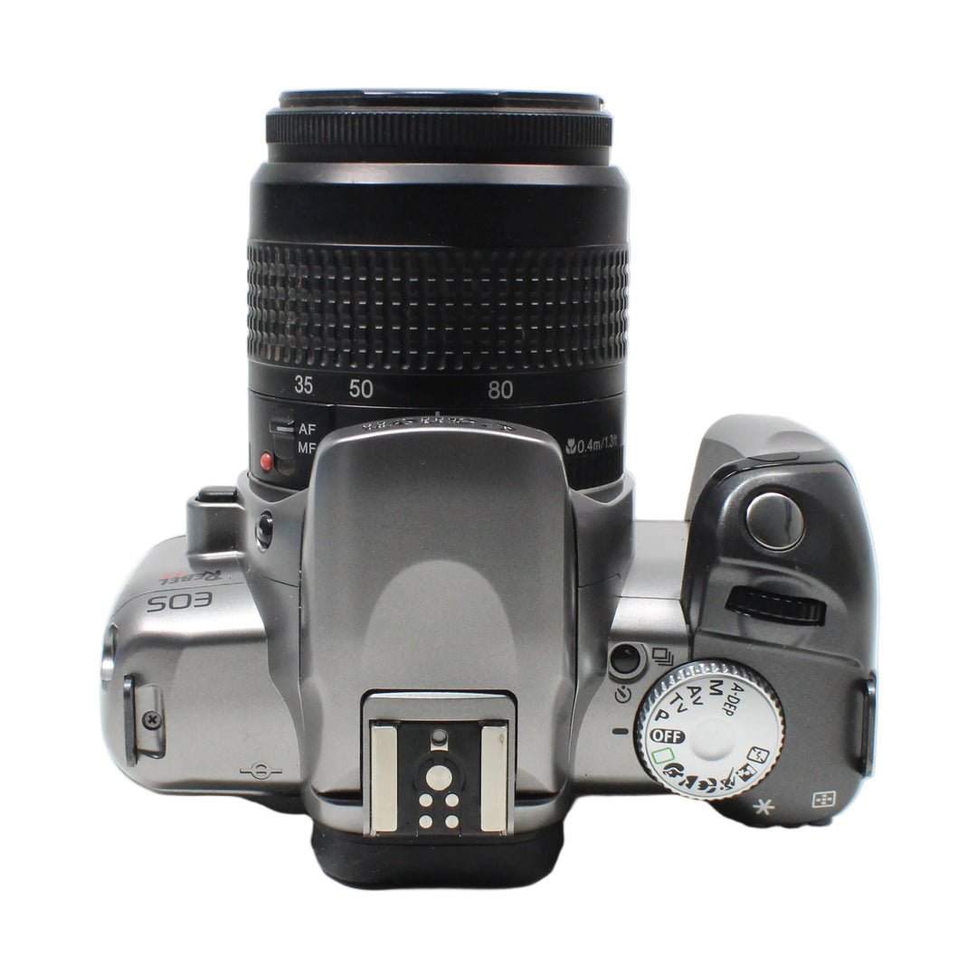 Canon Rebel T2 silver film camera top view with mode dial and EF 35-80mm zoom lens at ClubCamera.com