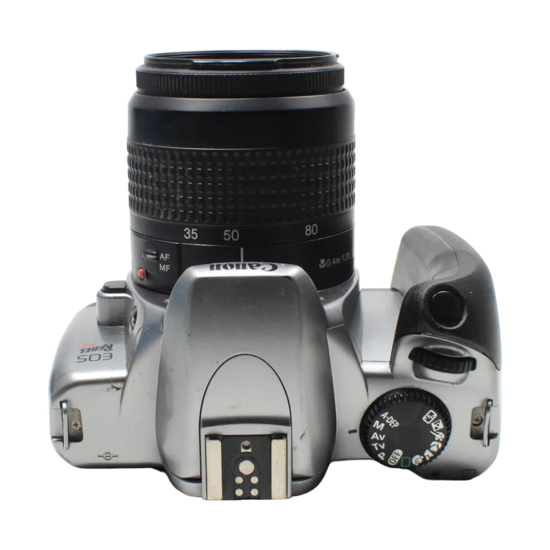 ClubCamera.com top-down Canon EOS Rebel K2 showing mode dial, AF/MF switch, and pop-up flash on silver body