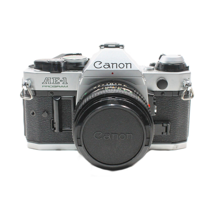 Canon AE-1 Program 35mm SLR camera with attached black front lens cap featuring embossed logo at ClubCamera.com