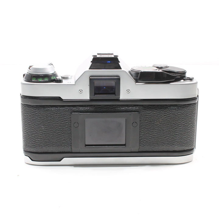 Rear view of Canon AE-1 Program highlighting black pebbled leatherette grip, blue-tinted viewfinder eyepiece, and metal base plate