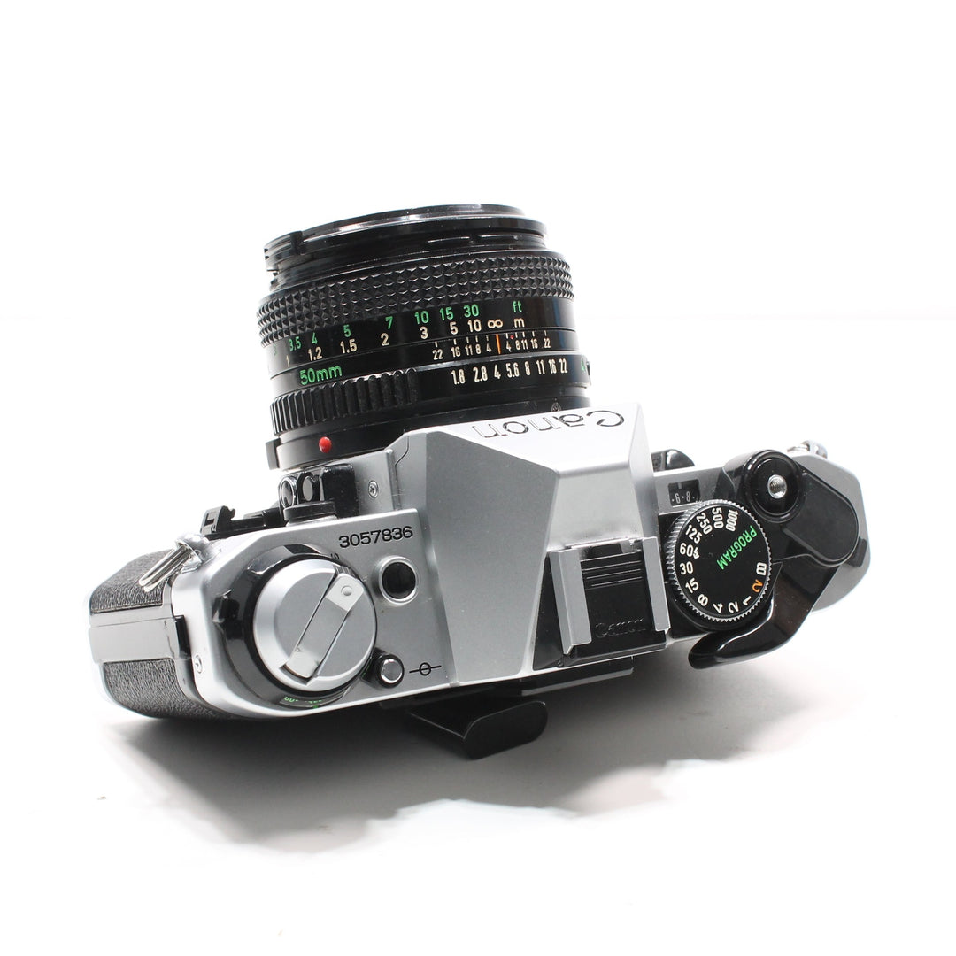 Top view of Canon AE-1 Program showing silver shutter dial, green PROGRAM mode indicator, and serial number 3057836