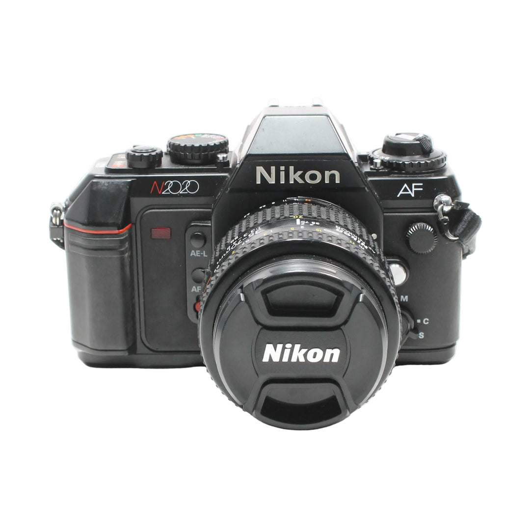 Close-up of black Nikon N2020 SLR with lens cap on featuring silver and red branding from ClubCamera.com