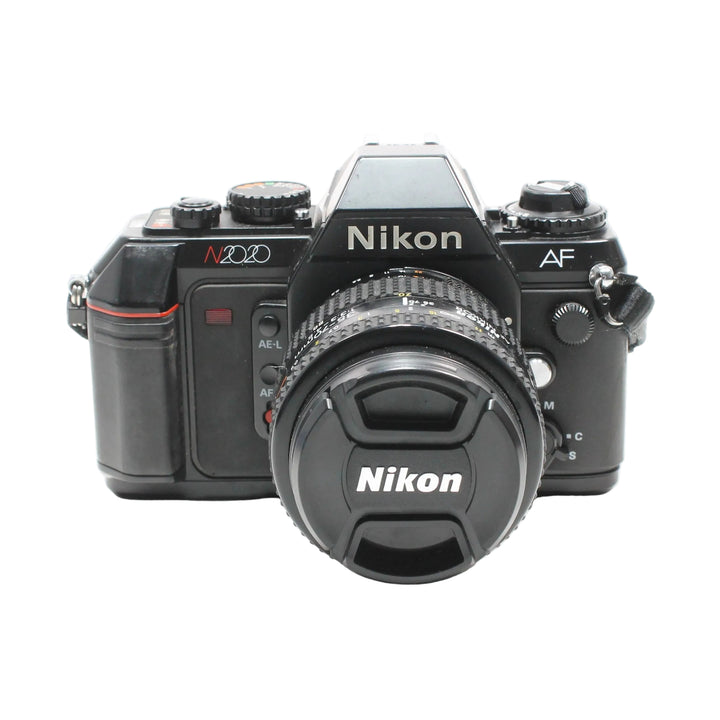 Close-up of black Nikon N2020 SLR with lens cap on featuring silver and red branding from ClubCamera.com