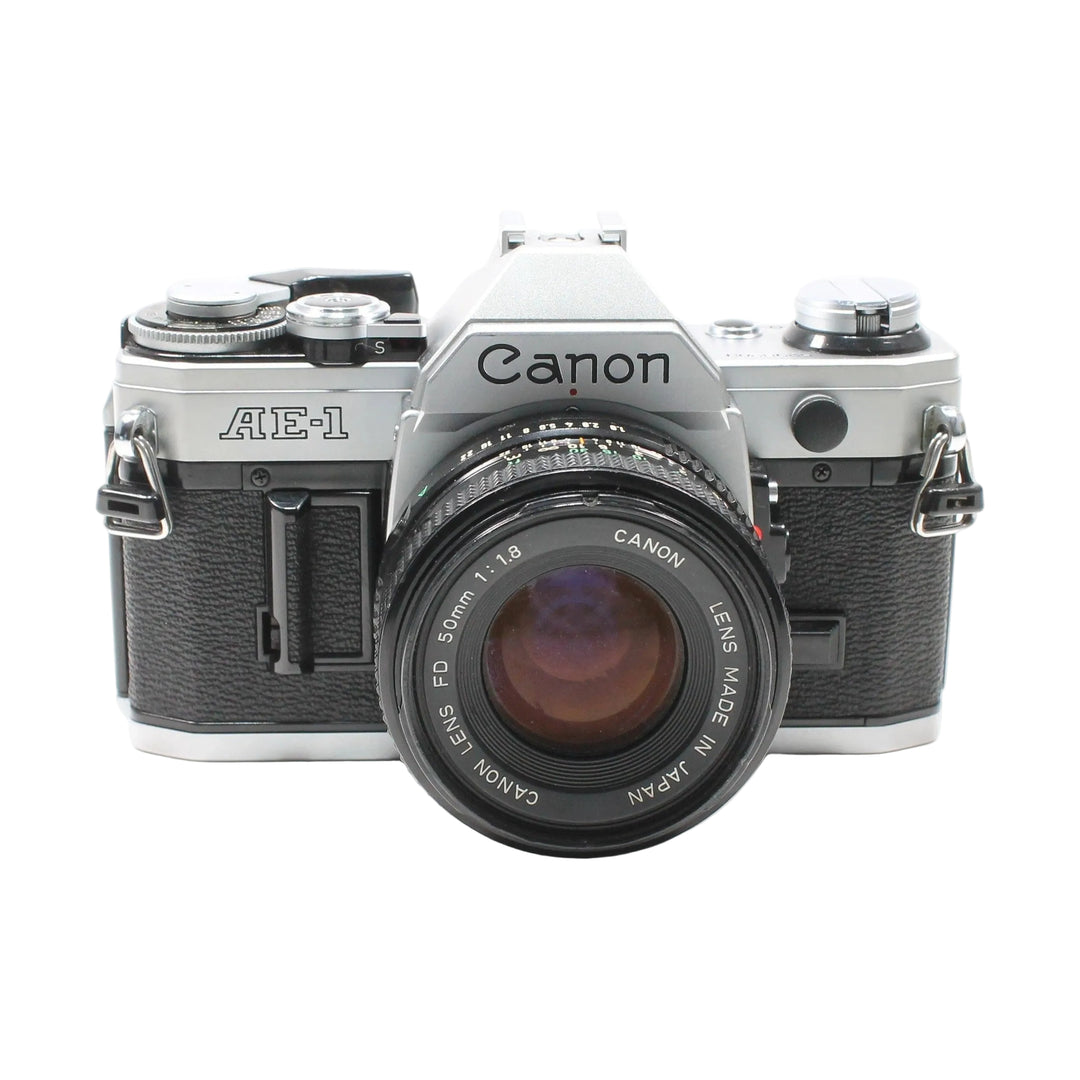 Canon AE-1 35mm SLR film camera with FD 50mm lens at ClubCamera.com showing black leatherette body and silver top plate