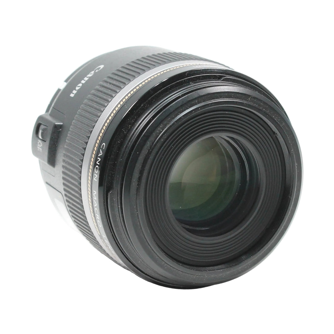 Canon EF-S 60mm f/2.8 Macro USM lens side angle showing front glass element ridges and Canon branding
