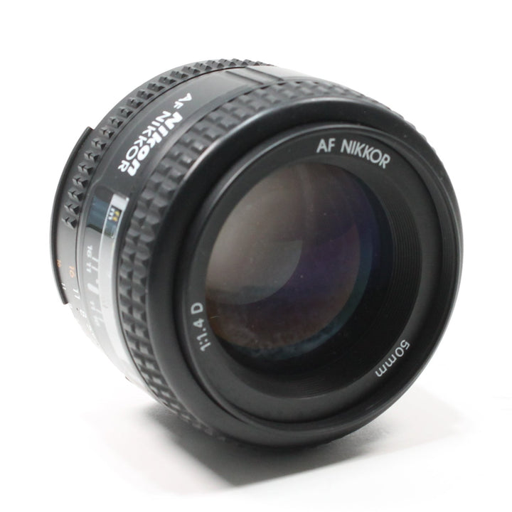 Black Nikon AF Nikkor 50mm f/1.4D lens showing glossy front element and purple-blue coating by ClubCamera.com