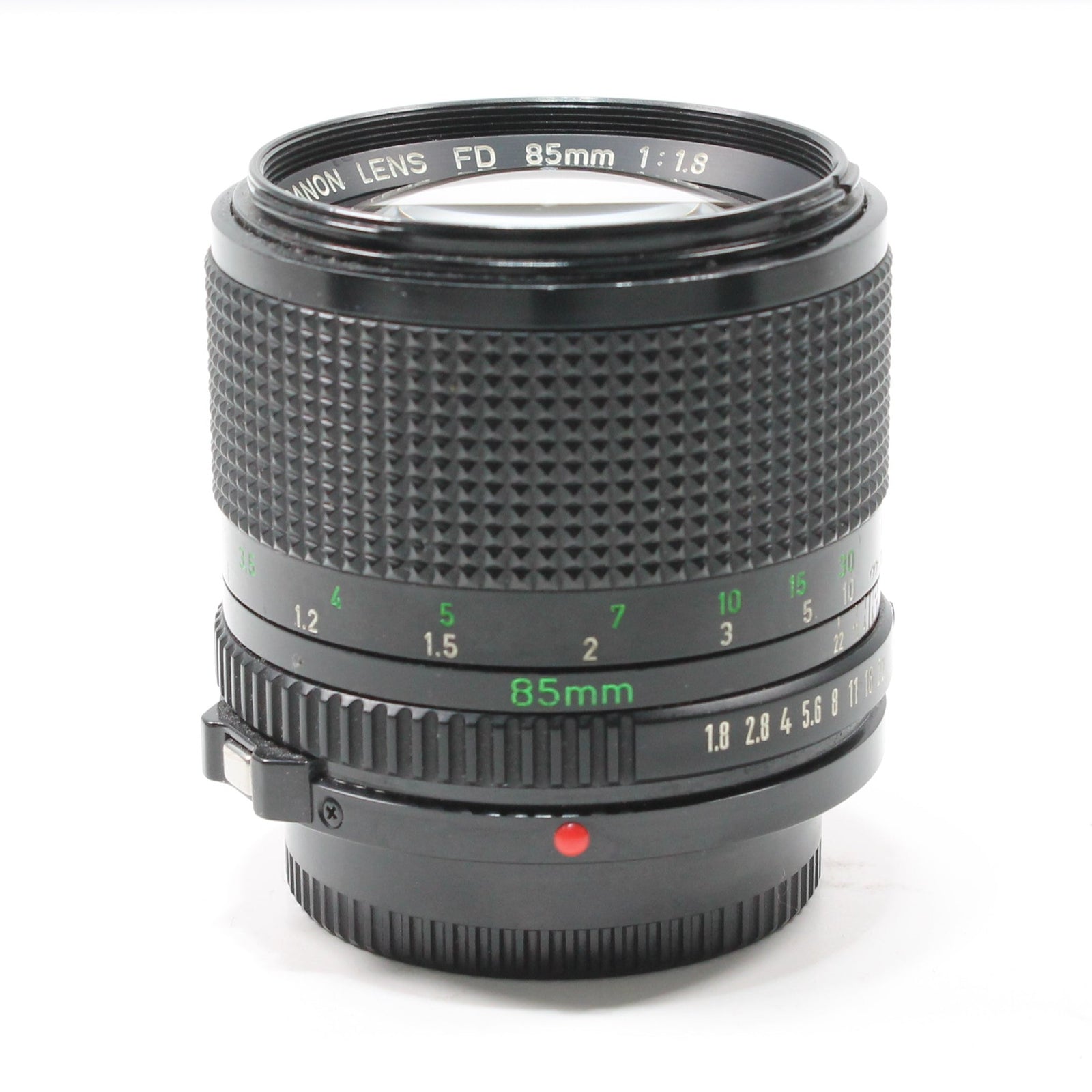 Close-up of black Canon FD 85mm f/1.8 prime lens with green engraved markings and red alignment dot from ClubCamera.com
