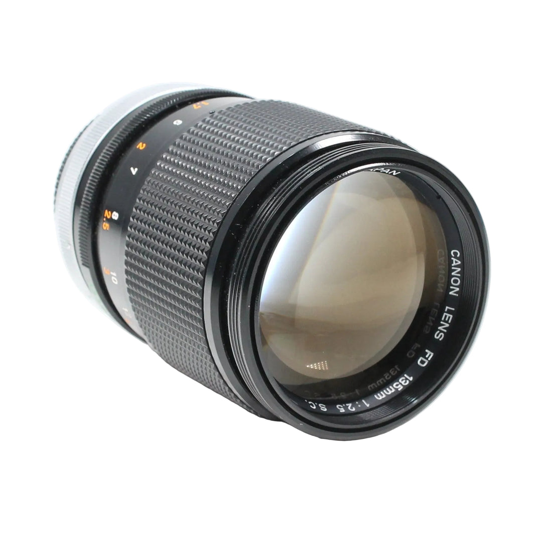 Canon FD 135mm f/2.5 S.C. telephoto lens at ClubCamera.com with orange aperture ring and textured focus grip