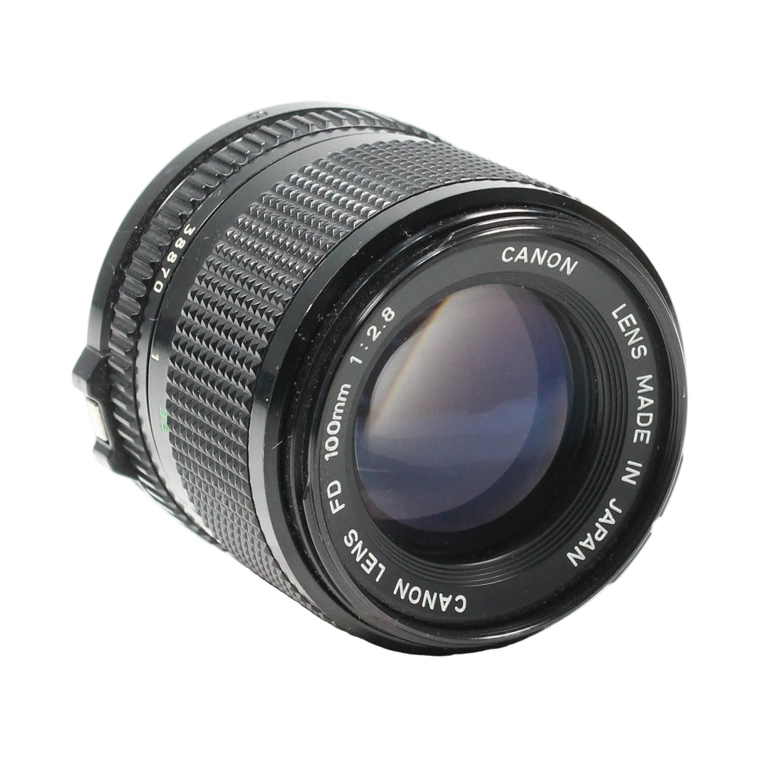 Canon FD 100mm f/2.8 manual focus telephoto lens by ClubCamera.com with matte black finish and engraved Japanese text