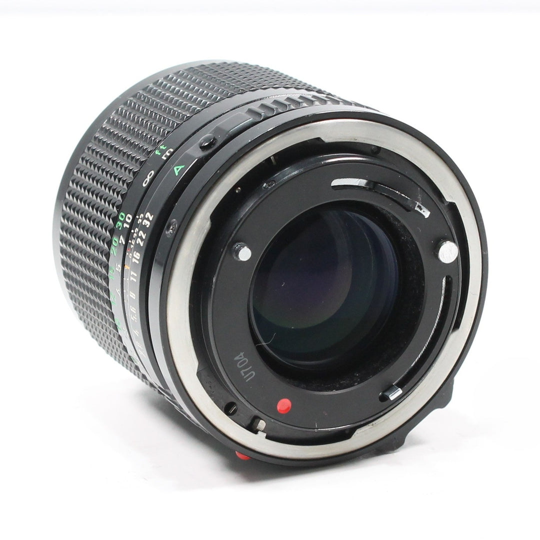 Back view of Canon FD mount 100mm f/2.8 lens at ClubCamera.com showing silver bayonet ring and green aperture scale
