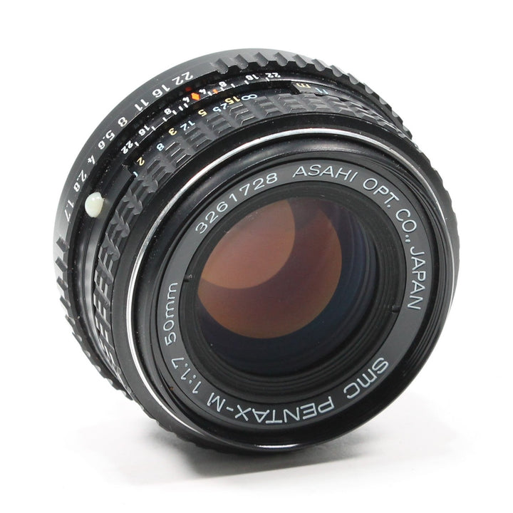 ClubCamera Pentax 50mm f/1.7 prime lens side view with amber glass reflections and white distance markings