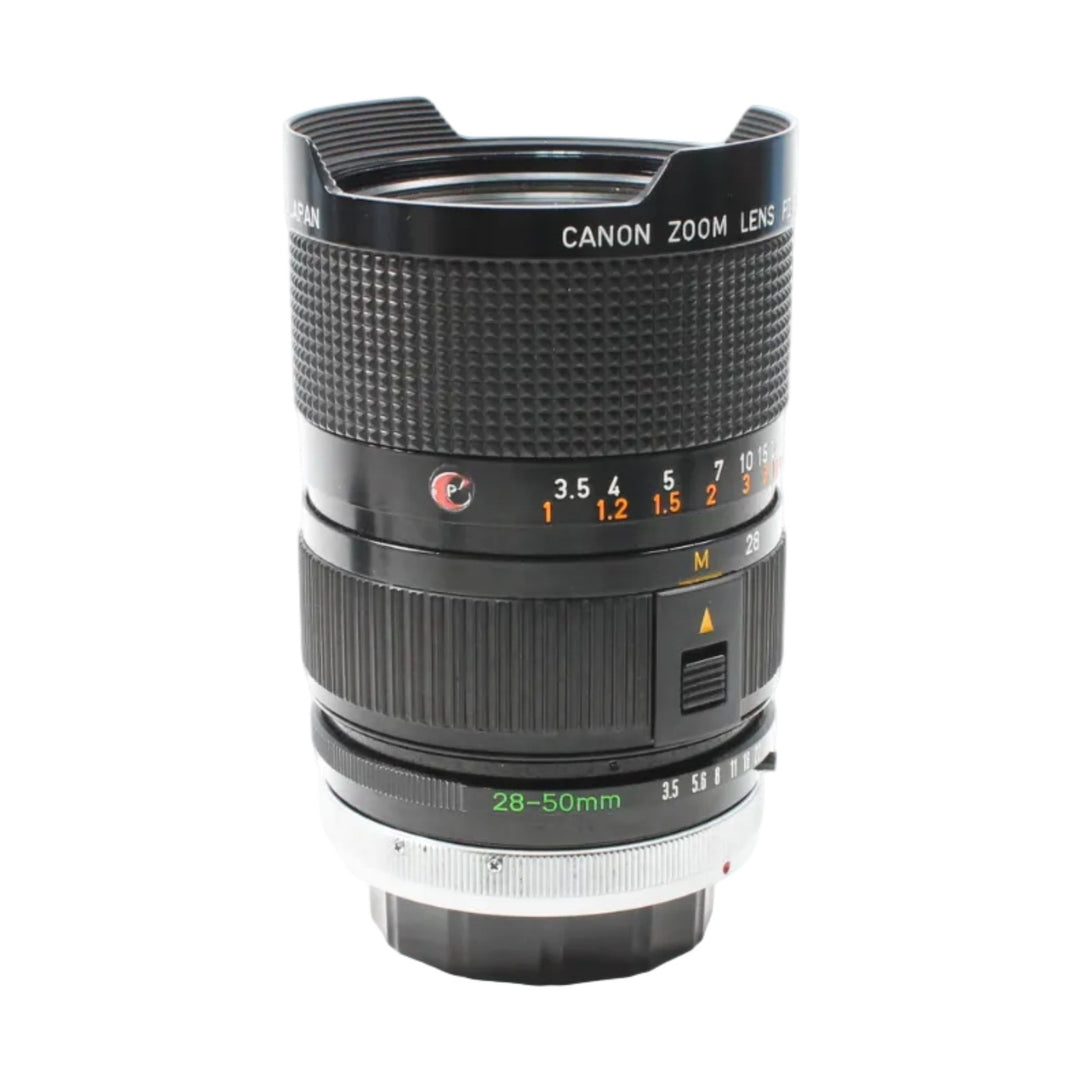 Front shot of black Canon FD 28-50mm zoom lens with textured grip and white lettering at ClubCamera.com