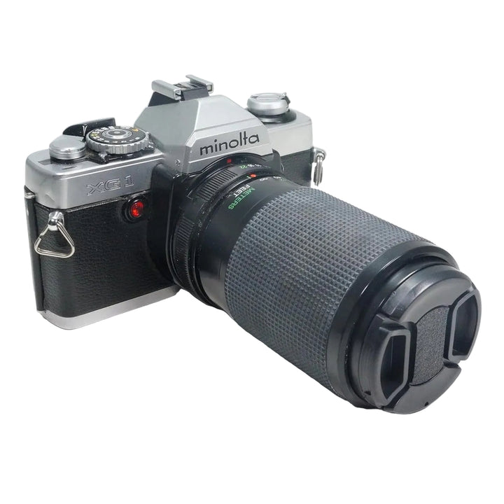 ClubCamera.com silver and black Minolta XG-1 35mm SLR film camera with telephoto lens