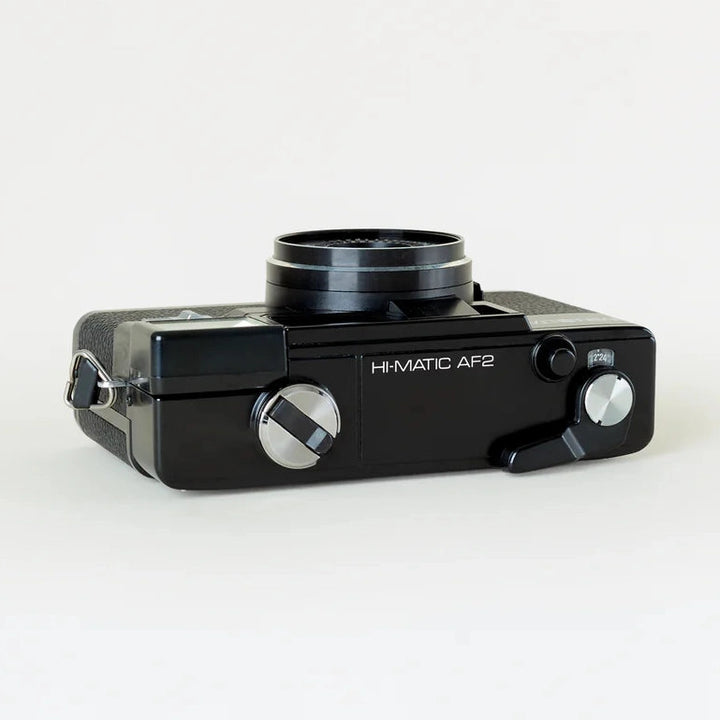 Black Minolta Hi-Matic AF2 film camera top rear view with textured grip and silver advance knob at ClubCamera.com