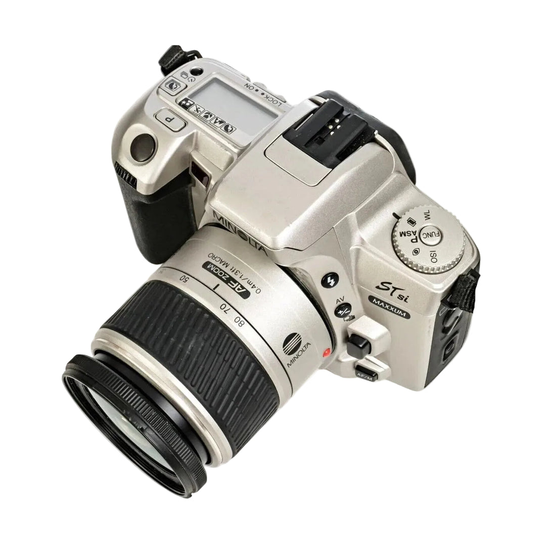 Top view of silver Minolta Maxxum STsi showing mode dial, LCD screen, and AF/M switch at ClubCamera.com