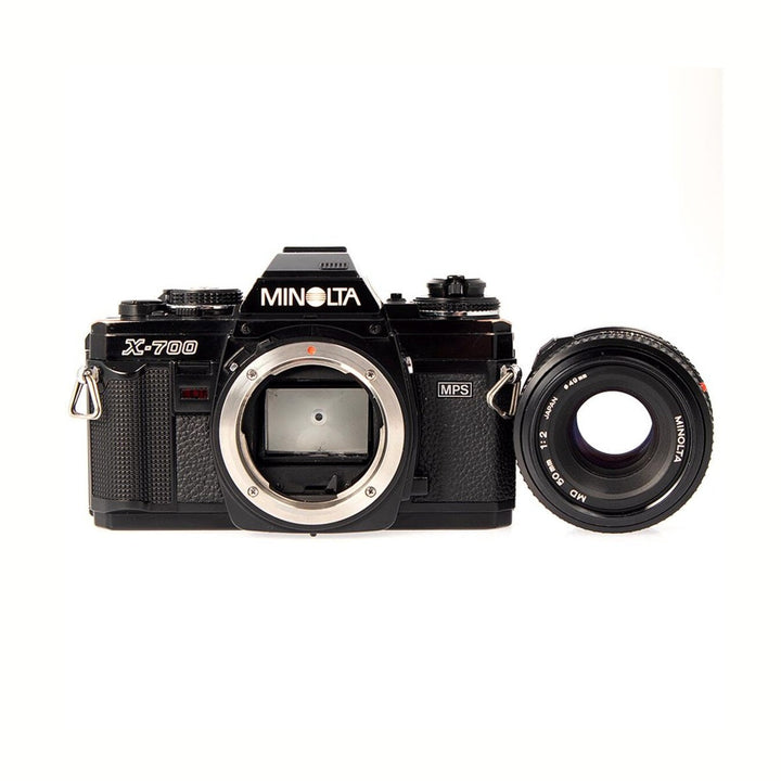 ClubCamera.com black Minolta X-700 SLR body with detached MD 50mm f/2 lens showing engraved markings and sensor mount