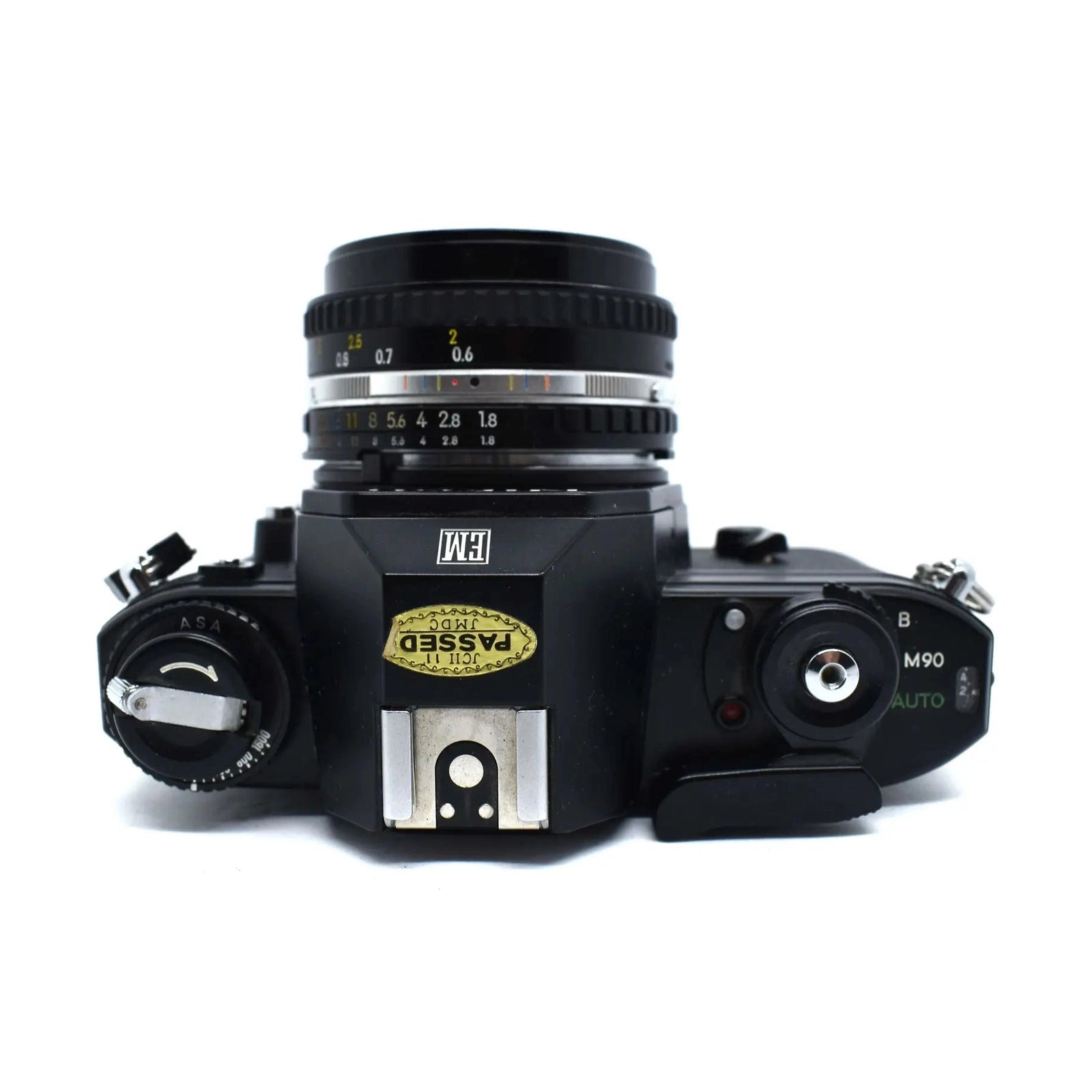 Top-down black Nikon EM 35mm SLR film camera showing aperture ring and ISO dial at ClubCamera.com