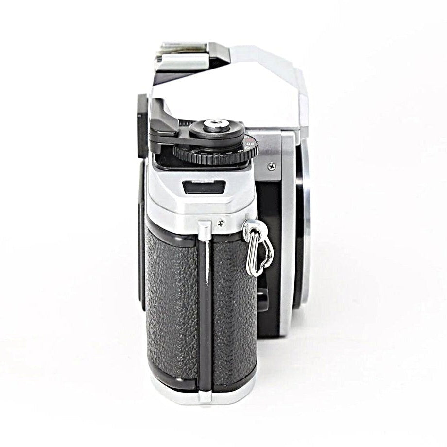 Nikon FG-20 silver and black SLR film camera side profile with textured grip and chrome top plate at ClubCamera.com