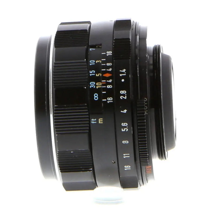 Side view of Pentax 50mm f/1.4 manual focus lens showing distance scale and aperture ring markings for ClubCamera.com