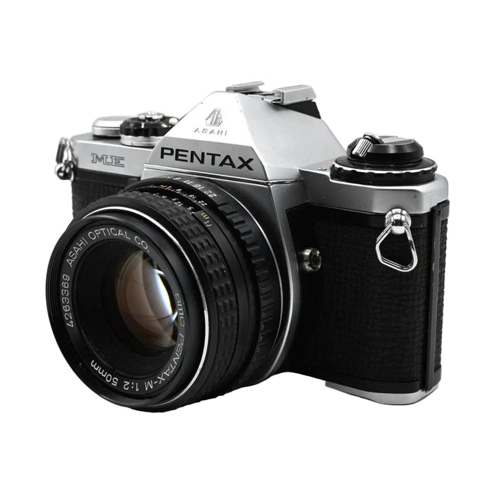 Silver Pentax ME SLR camera side profile with knurled focus ring and black textured grip visible at ClubCamera.com