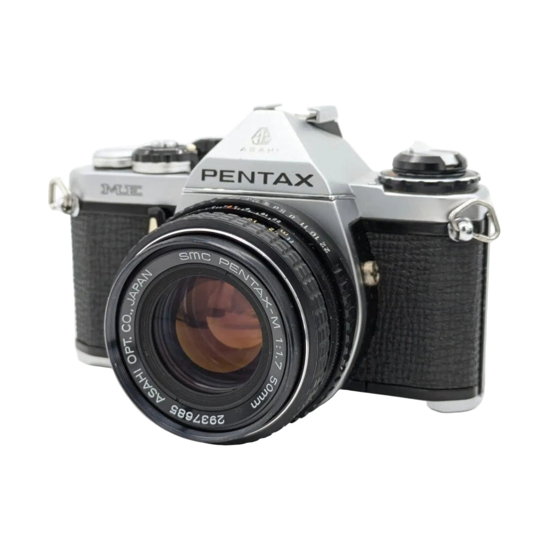 ClubCamera.com front three-quarter view of silver Pentax ME manual focus SLR camera with SMC Pentax-M 50mm lens and chrome shutter dial