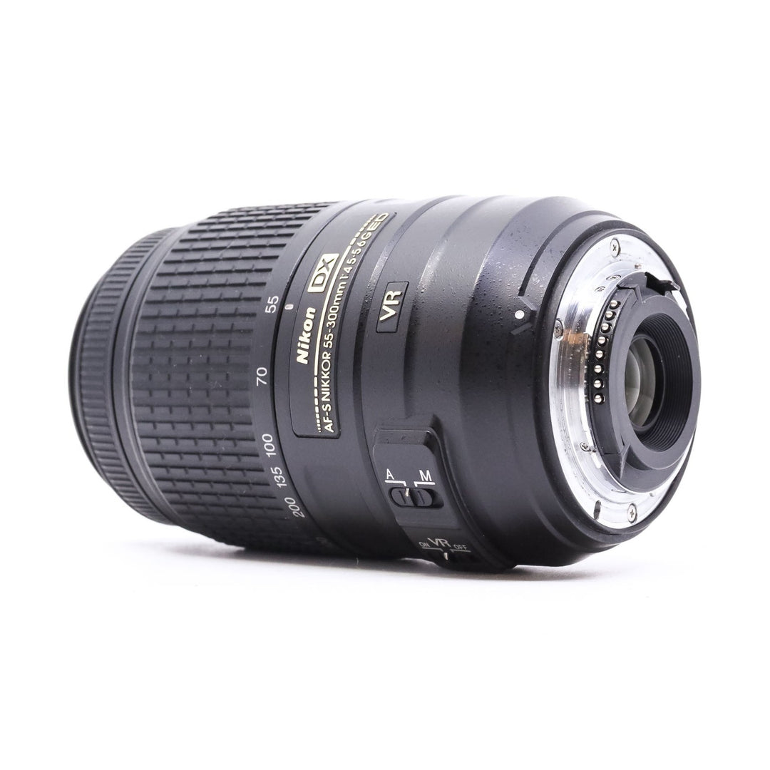 Rear mount interface of black Nikon DX 55-300mm VR lens showing metal contacts and zoom scale at ClubCamera