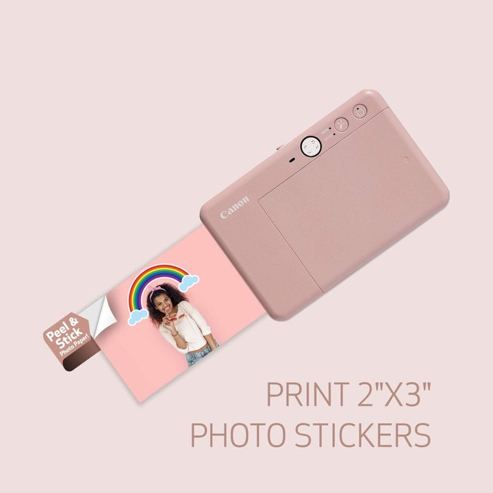 Rear view of rose gold Canon IVY CLIQ+2 printer ejecting 2x3 adhesive photo sticker at ClubCamera.com