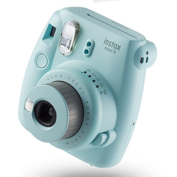 ClubCamera.com Fujifilm Instax Mini 9 Ice Blue side view showing ergonomic grip and textured focus ring