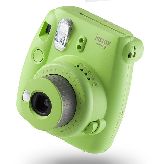 Lime green Fujifilm Instax Mini 9 side view showing focus ring and ergonomic grip at ClubCamera.com